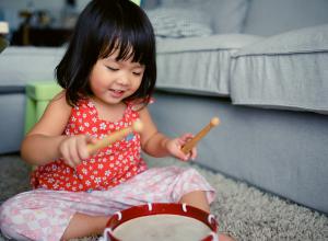 Little girl playing the drum