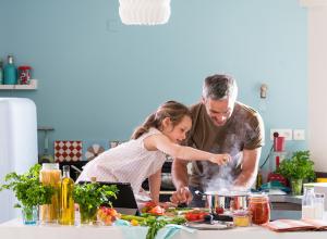 Parent making meal with daughter