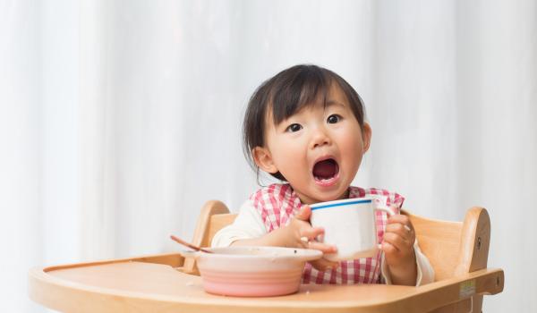Child eating food and showing teeth
