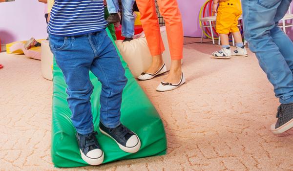 Children running inside in a designated play space.