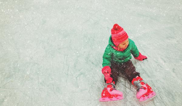 Child on ice rink wearing skates