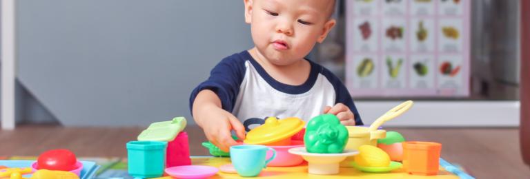 Infant playing with plastic food