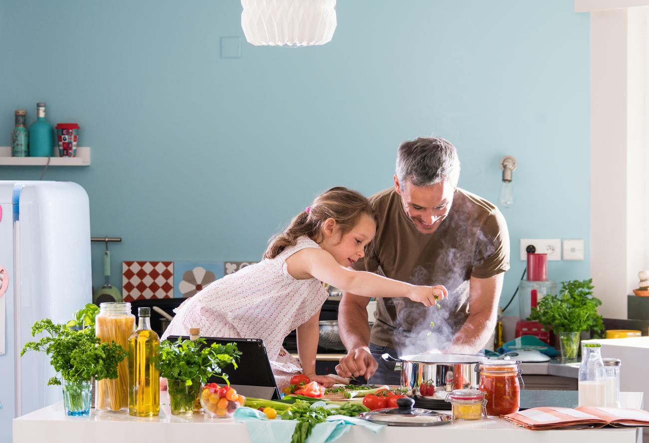 Parent making meal with daughter